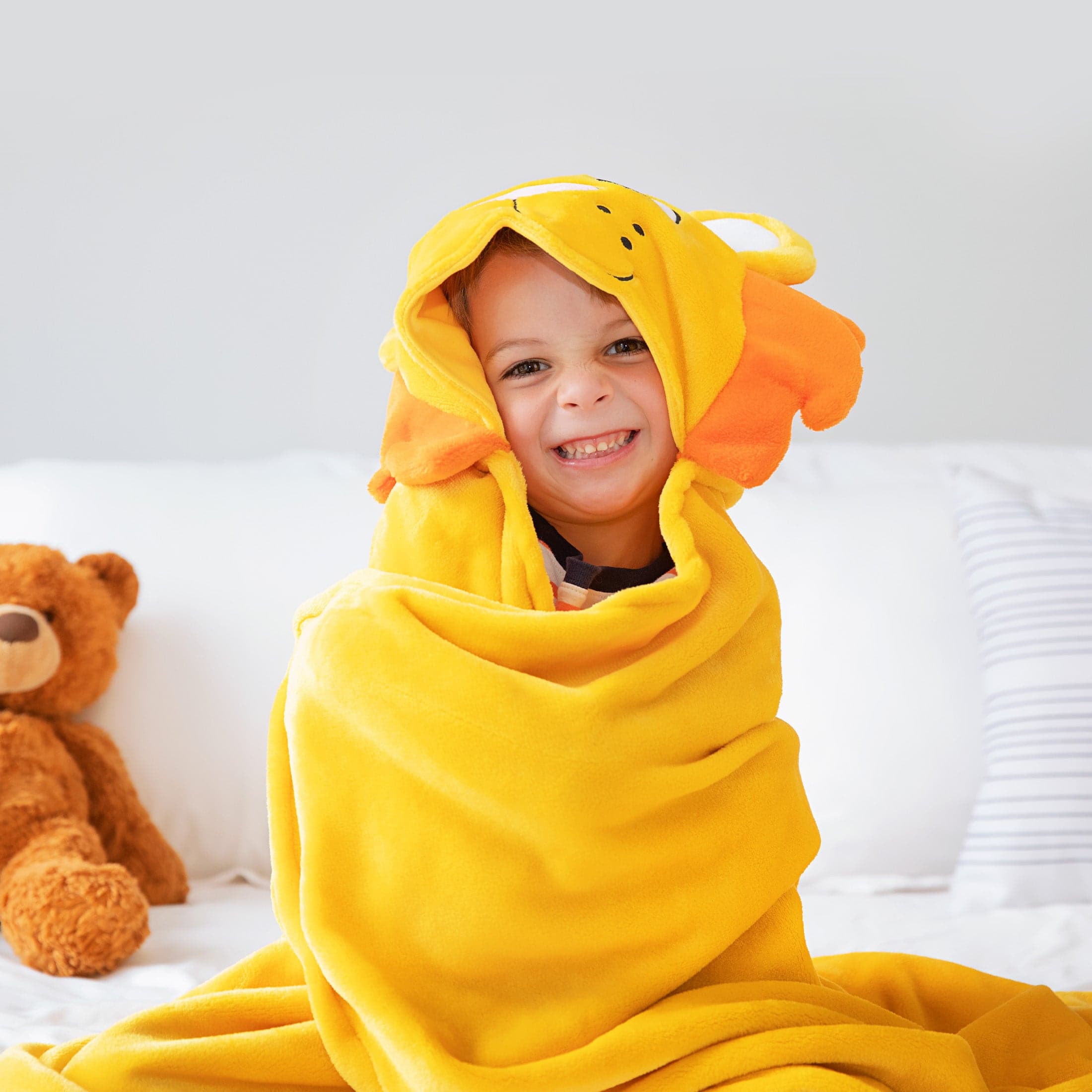 Child smiling in a lion Canoogles blanket