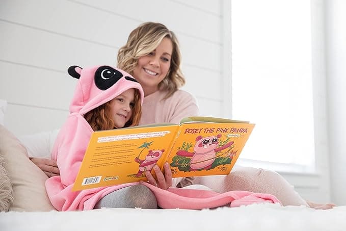 A parent and child reading Posey while wrapped in a pink panda blanket